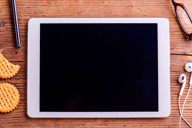 istock Tablet, earphones, eyeglasses laid on office desk, studio shot 544794350