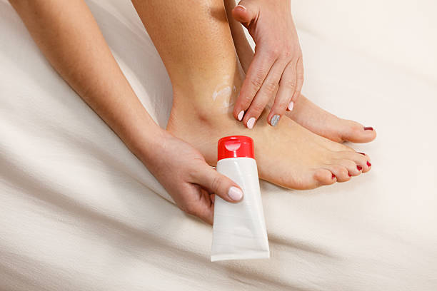 istock Woman putting ointment on bad ankle applying cream 544795852