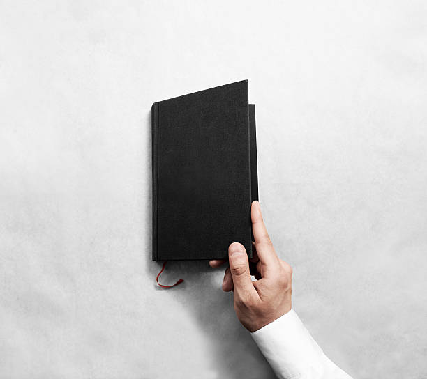 istock Hand open blank black book cover mock up template. 544797648