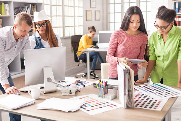 Team of young creative designers working at modern workplace