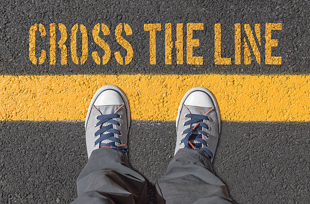 Sneakers standing on the yellow line. stock photo