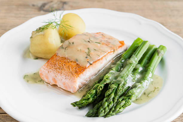 istock Grilled salmon with boiled potatoes and asparagus on white plate 544802620