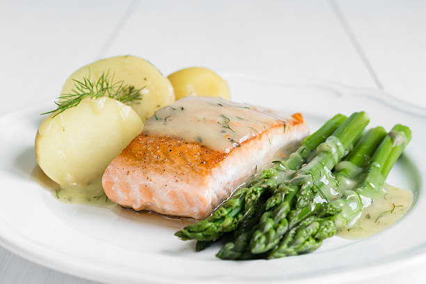 istock Grilled salmon with boiled potatoes and asparagus on white plate 544802832