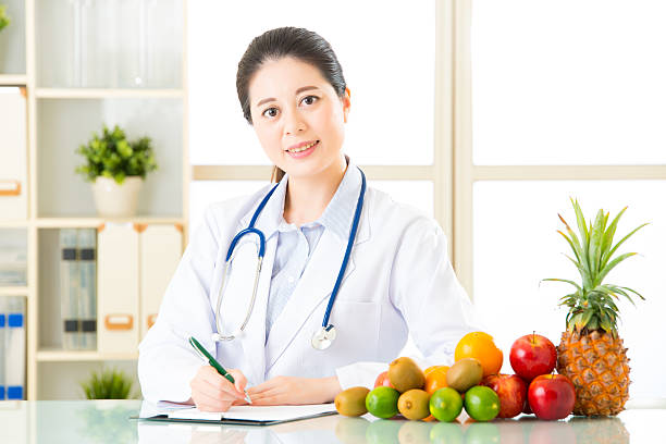 istock Young asian nutritionist doctor writing diet plan 544803782