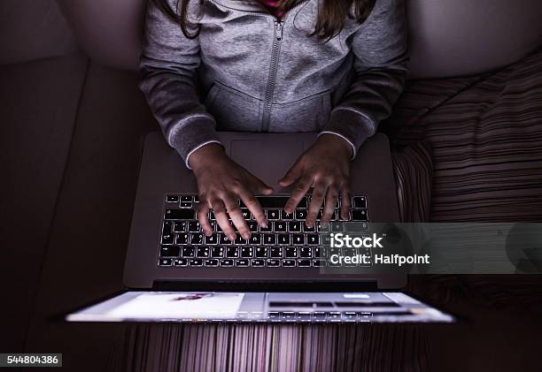 Unrecognizable Girl Sitting In A Dark Playing With Laptop Stock Photo - Download Image Now