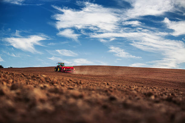 Farmer in tractor preparing farmland with seedbed for the next year