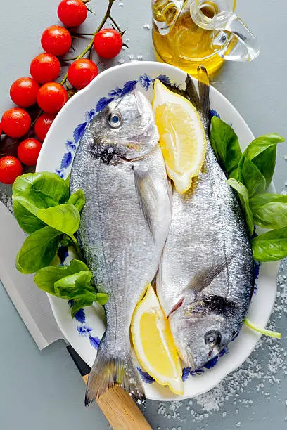 Delicious two fresh fish  with aromatic herbs, spices and vegetables - healthy food, diet or cooking concept