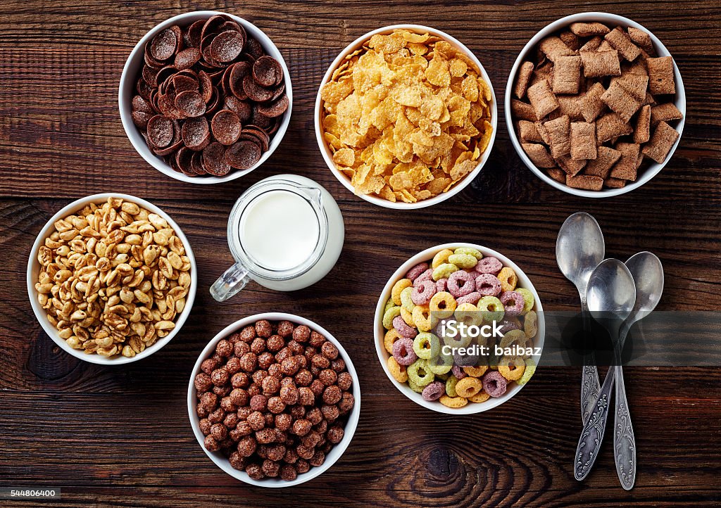 Bowls of various cereals Bowls of various cereals and milk from top view Cereal Plant Stock Photo