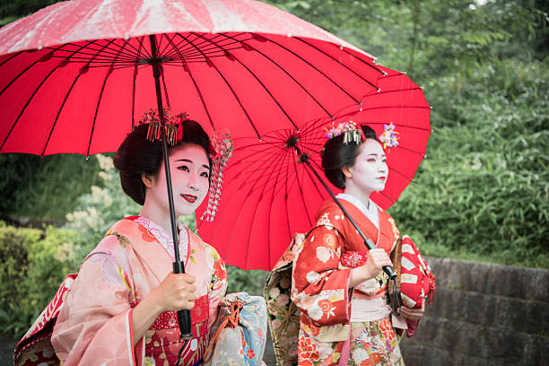 istock Two Japanese geishas with red umbrellas in kimonos 544806964