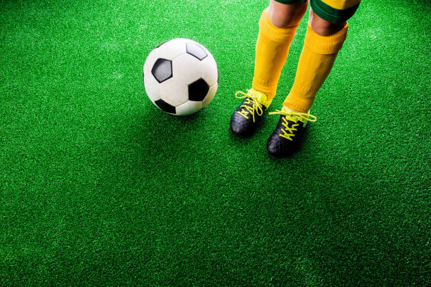 istock Unrecognizable little football player against green grass, studi 544809616