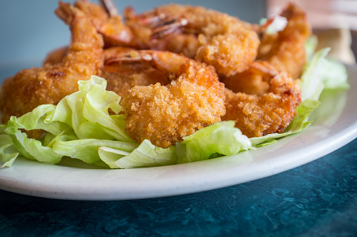 Large serving of popcorn shrimp tempura appetizer on bed of lettuce