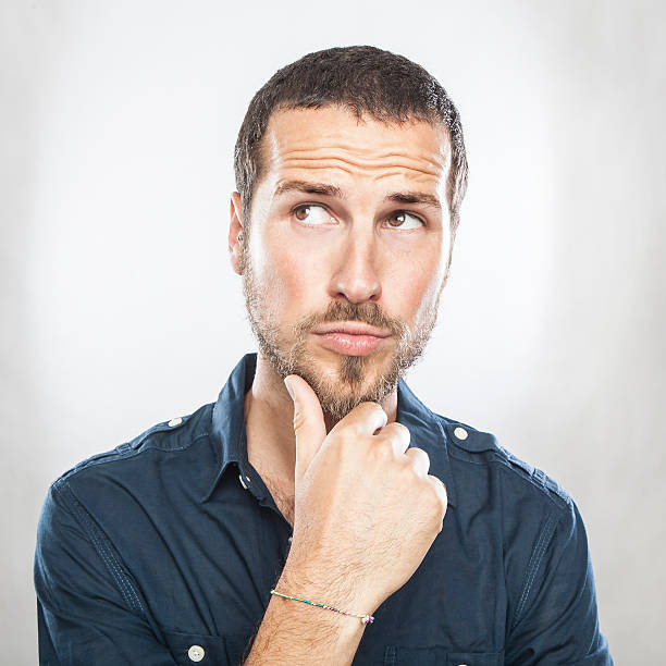 istock Portrait of handsome young thoughtful man isolated over white ba 544813584