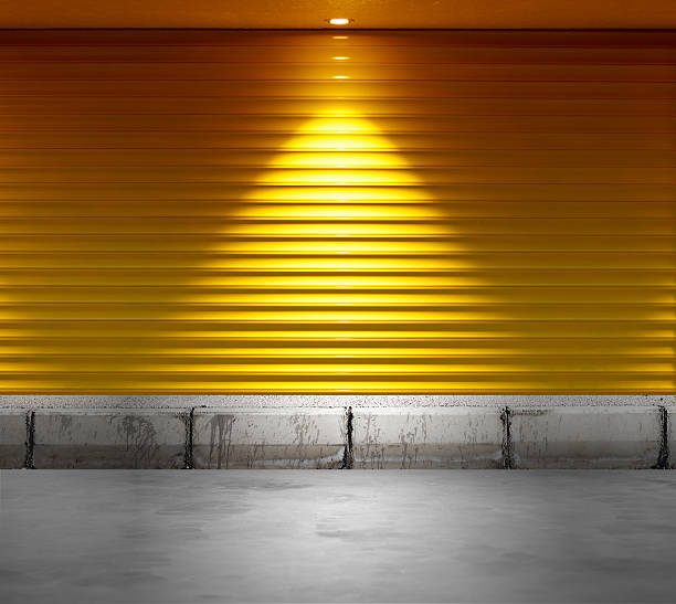 Empty shop with metallic roller shutter yellow door Empty shop with metallic roller shutter yellow door shutter door stock pictures, royalty-free photos & images