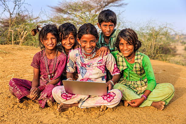 istock Happy Indian children using laptop, desert village, India 544815406