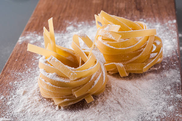 istock raw tagliatelle with flour on brown wooden table 544817614