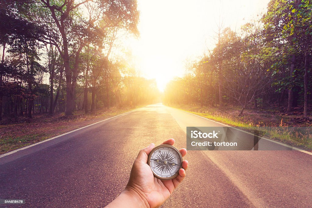 Handhalten Kompass auf leeren Asphalt Straße und Sonnenuntergang. - Lizenzfrei Kompass Stock-Foto