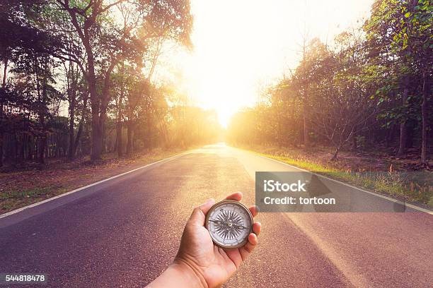 Handhalten Kompass Auf Leeren Asphalt Straße Und Sonnenuntergang Stockfoto und mehr Bilder von Kompass