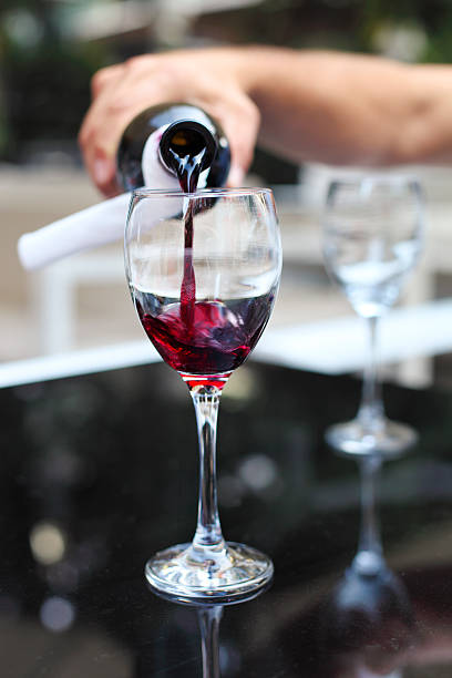 istock Pouring red wine from bottle into the wineglass 544818630