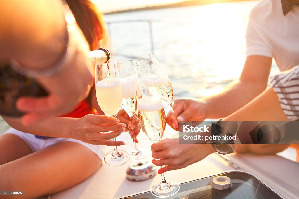 Amigos felices con copas de champán en yate. Vacaciones, trav - Foto de stock de Yate libre de derechos