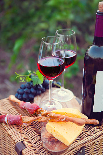 istock Two glasses of red wine with bread, grape and cheese 544818986