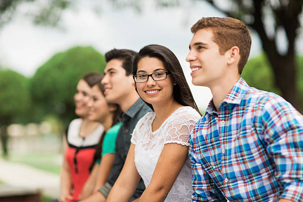istock Two young people sitting with friends in a row 544820404