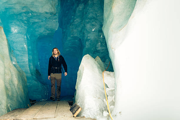 istock Young Man Hiking Through Glacier Cave 544820484