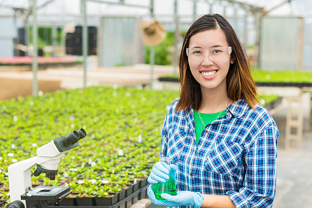Happy college student working in a greenhouse laboratory