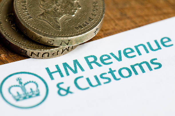 HM Revenue and customs forms and cash London, United Kingdom - July 6, 2016: HM Revenue and customs forms background with British currency coins. HMRC is the department of the UK government that is responsible for the collection of taxes. hm government stock pictures, royalty-free photos & images