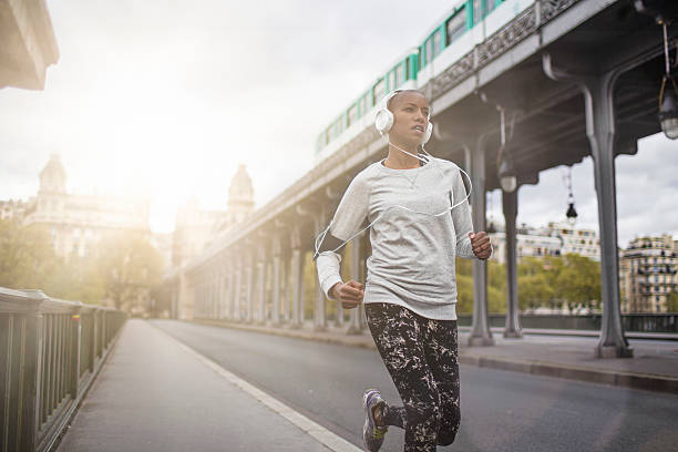 Woman running in Paris Woman running in the streets of Paris. shaved black women stock pictures, royalty-free photos & images