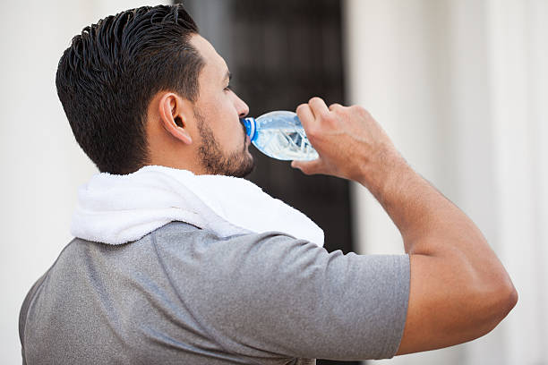 istock Closeup of a man drinking water from bottle 544959272