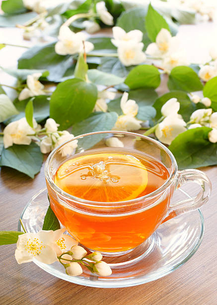 istock Tea with lemon and branches of a blooming jasmine 544963450