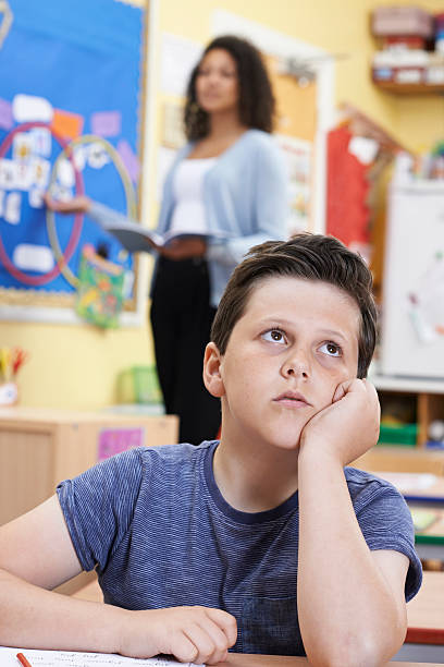 istock Male Elementary School Pupil Daydreaming In Class 544964984