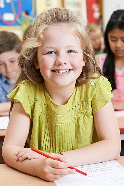 istock Portrait Of Female Elementary School Pupil Working At Desk 544965932