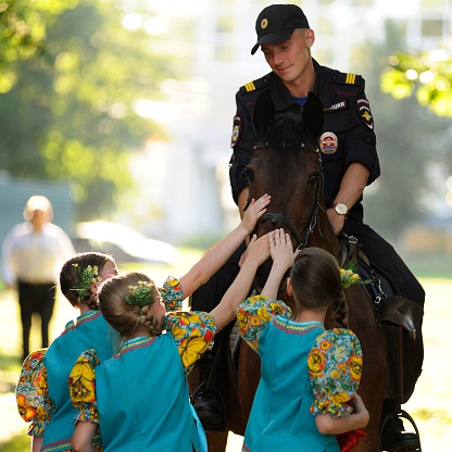 Orel, Russia - June 24, 2016: Turgenev Fest. Young Russian policeman on horse and little girls stroking it