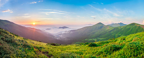 パノラマの下に白い霧が付いている山の美しい日の出 - carpathian mountain range ストックフォトと画像