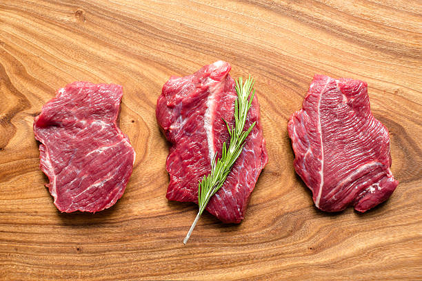 istock fresh raw meat on chopping board with rosemary, top view 544974484