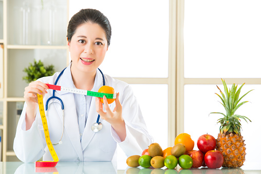 Young asian nutritionist recommend eating fruits, healthy eating