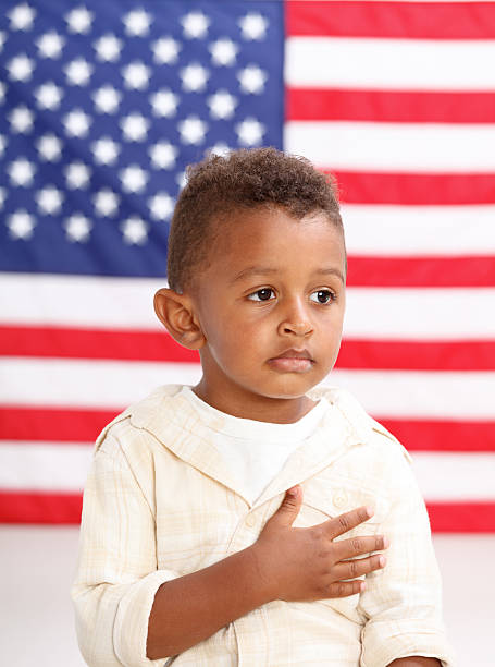 istock Boy in front of American flag with hand over heart 544985708