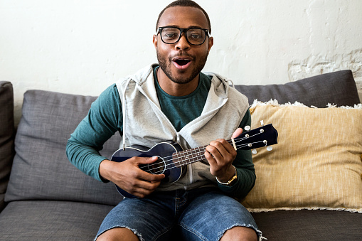 Guapo joven negro tocando la guitarra en casa. photo