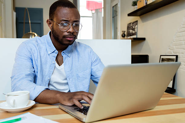 istock Handsome young black man working with laptop at home. 544994654