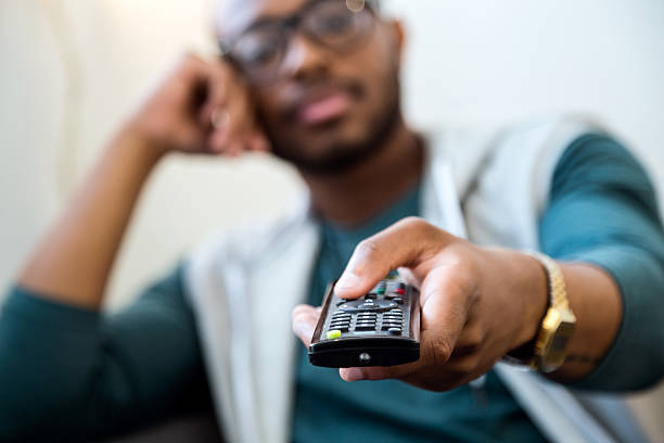 istock Handsome young black man watching tv at home. 544995194