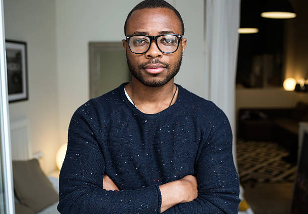 istock Handsome young black man looking at camera at home. 544996130