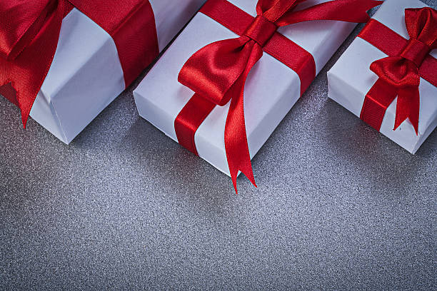 istock Boxed gifts with tied red ribbons on grey surface directly 544996590