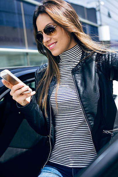 istock Beautiful young woman using her mobile phone in the car. 545081896