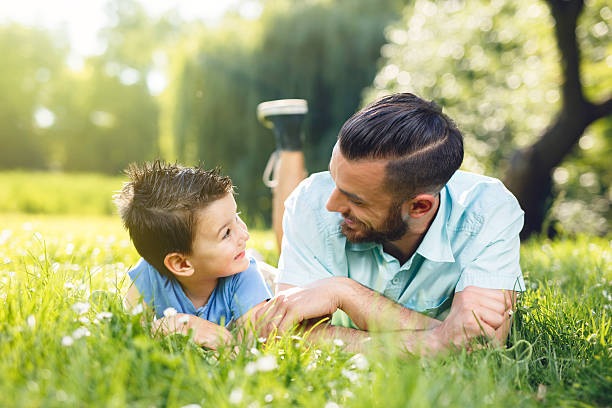 istock Father and son having fun lying on the grass. 545081974