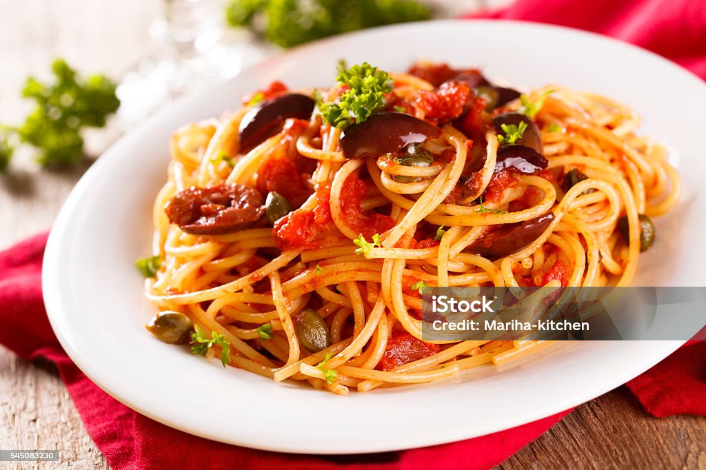 Puttanesca pasta Puttanesca pasta with olives, tomatoes and fresh parsley Puttanesca Stock Photo