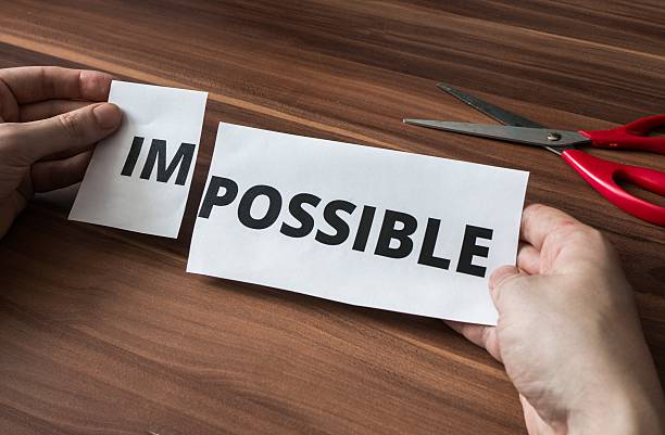 istock Possibility concept. Man is cutting paper with impossible word. 545083344
