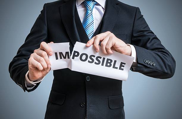 istock Possibility concept. Man is tearing paper with impossible word 545084116
