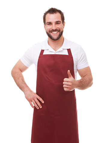 Happy man with red apron makes a gesture thumb up on white background