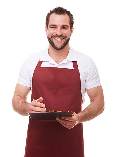 Smiling man writes on a black clipboard